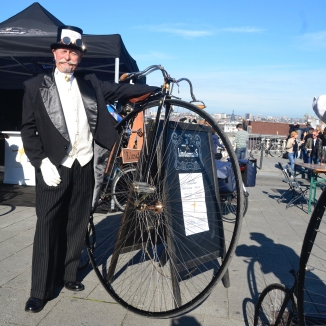 ©Barry Sandland/TIMB - Costumed rider standing next to his penny farthing